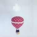 Duży balon z białą tasiemką, czerwony w białe gwiazdki